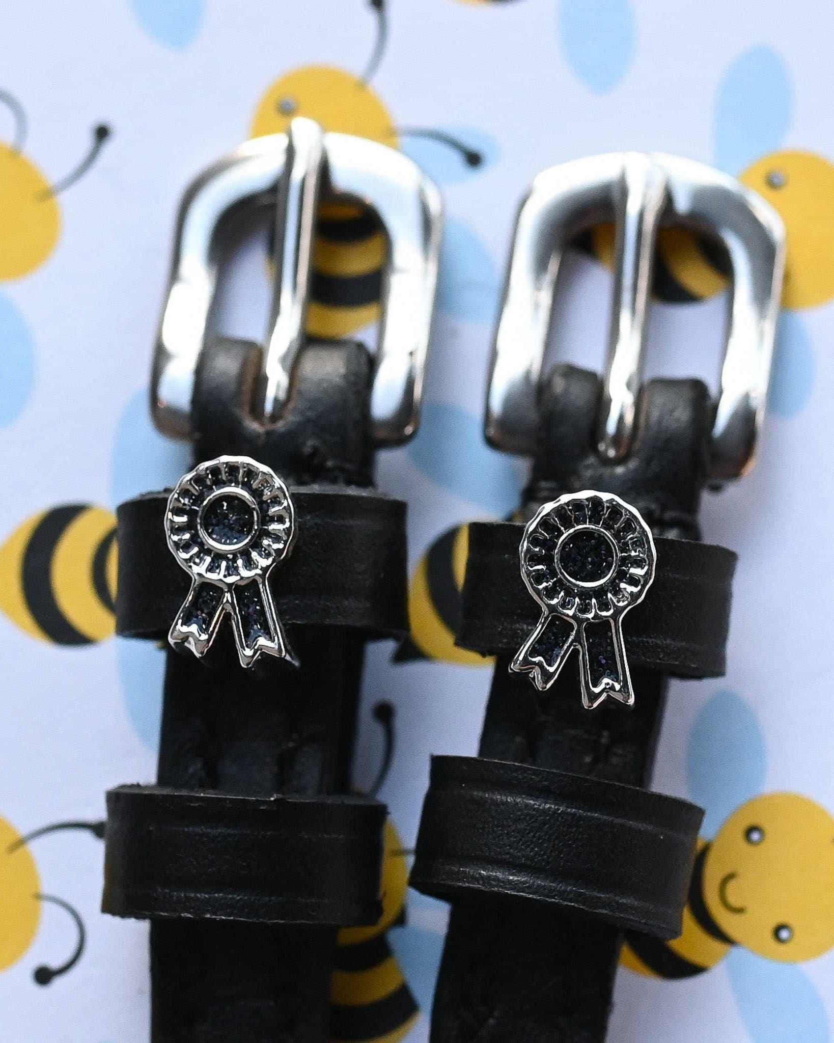 Rosette charm spur straps on black leather over a light blue bumblebee print
