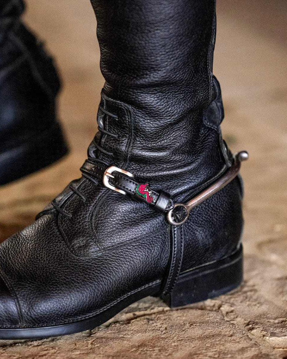 ManeJane seahorse spur strap fastened on a rider's black riding boot with spur