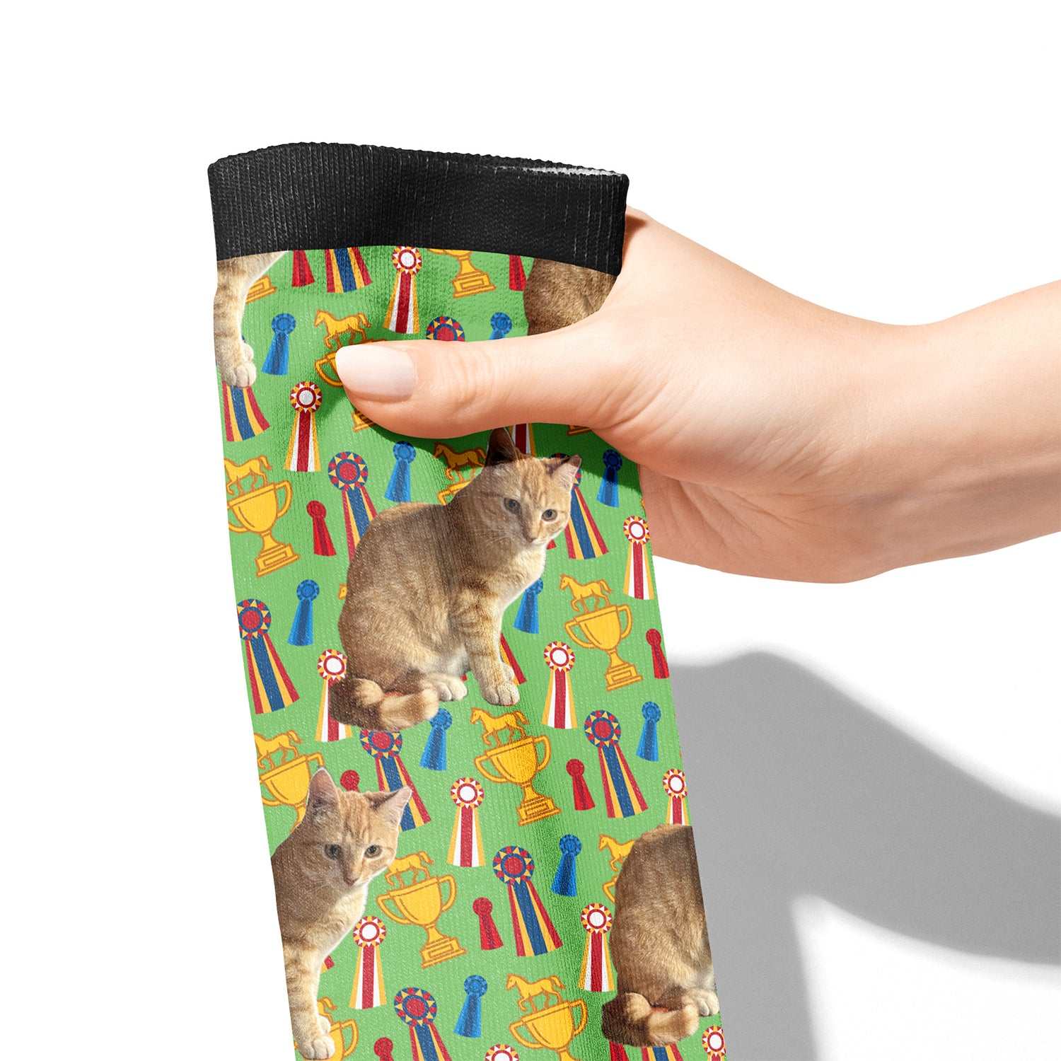 Hand holding custom green boot socks with cat and trophy pattern
