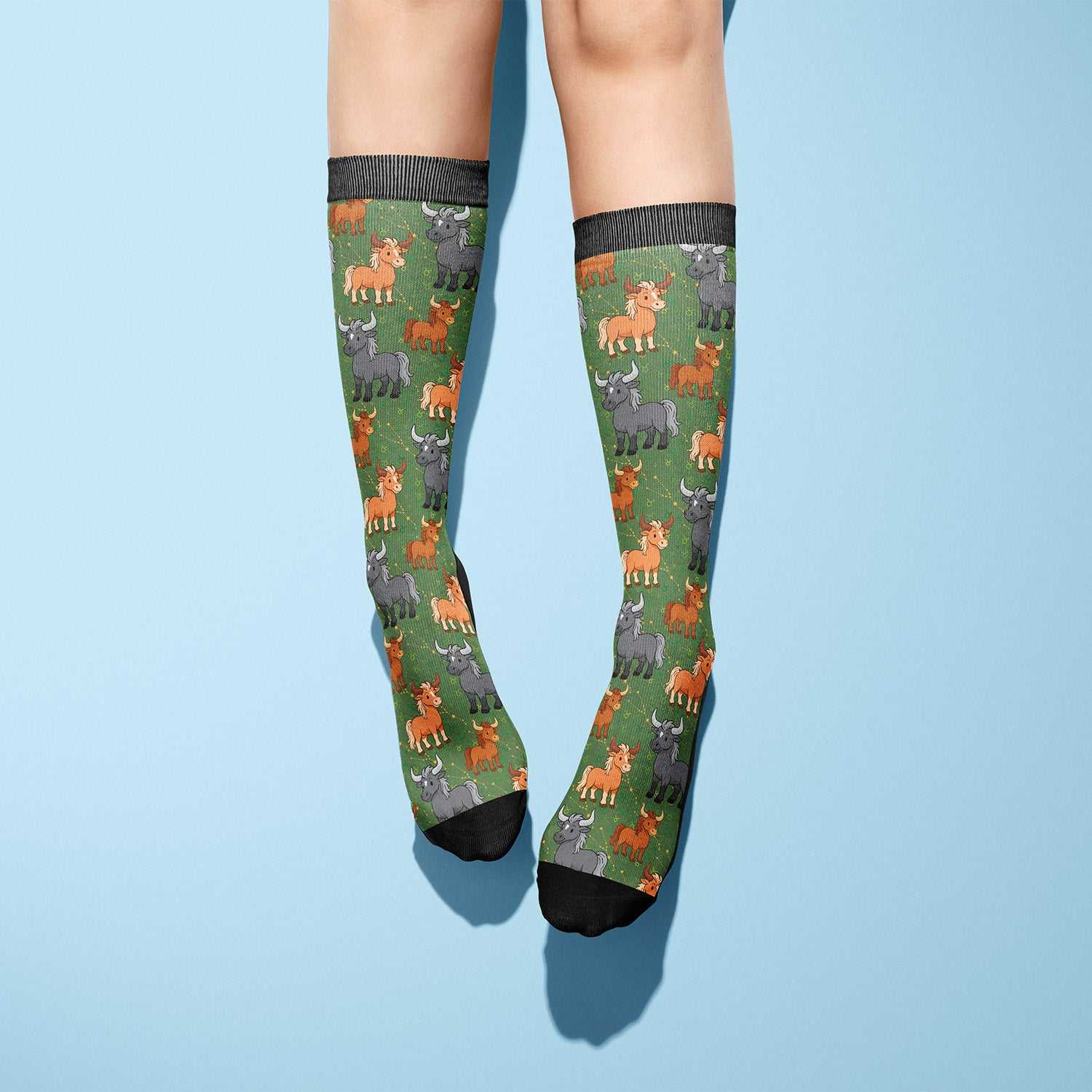 Taurus zodiac-themed boot socks with colorful bull patterns on green background