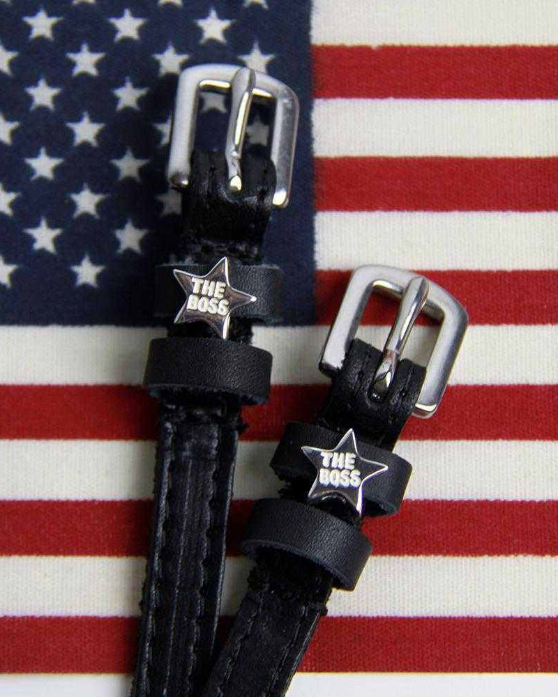 Black leather Boss star spur straps displayed on an American flag background
