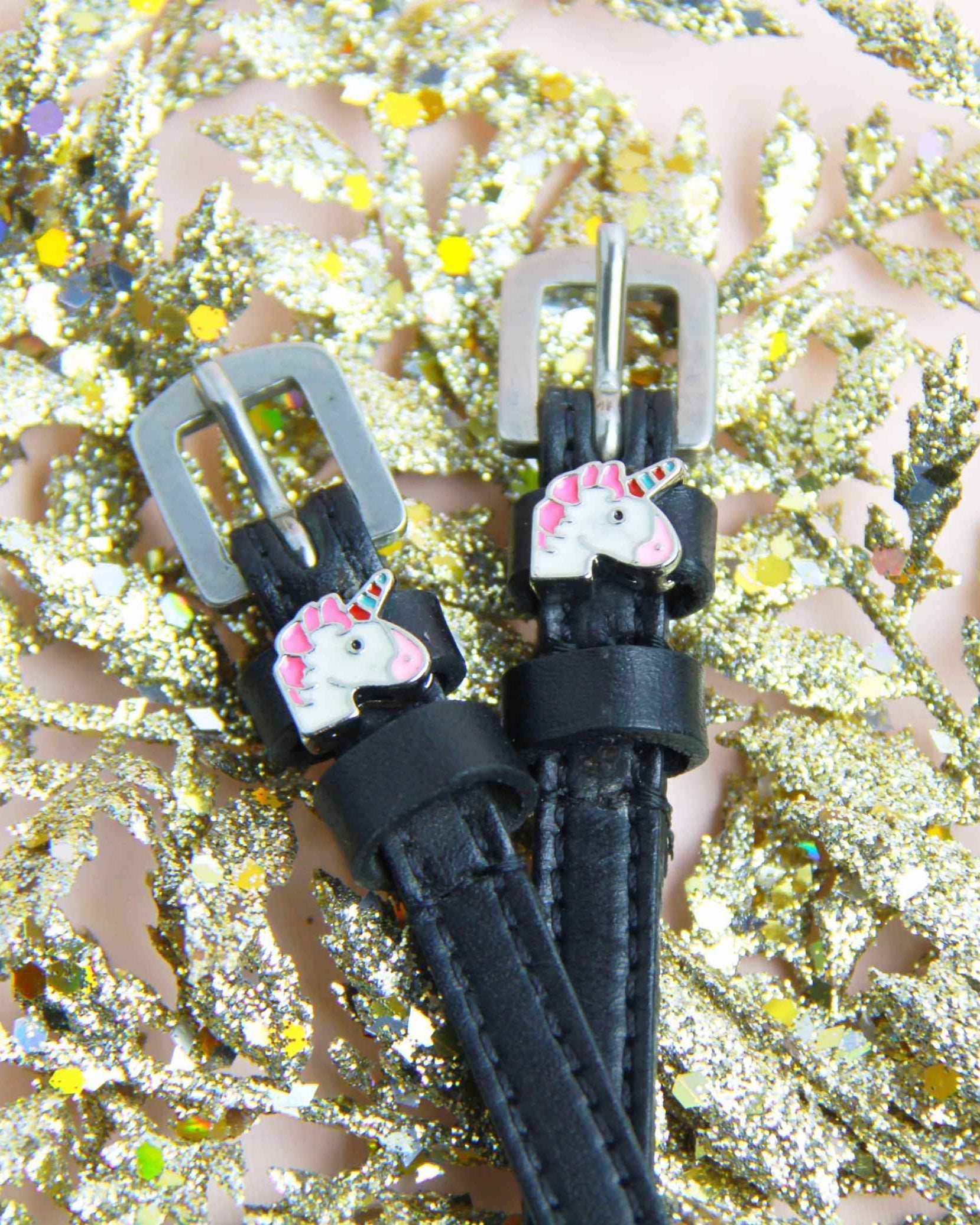 Unicorn charm spur strap buckle ends styled on gold glitter foliage