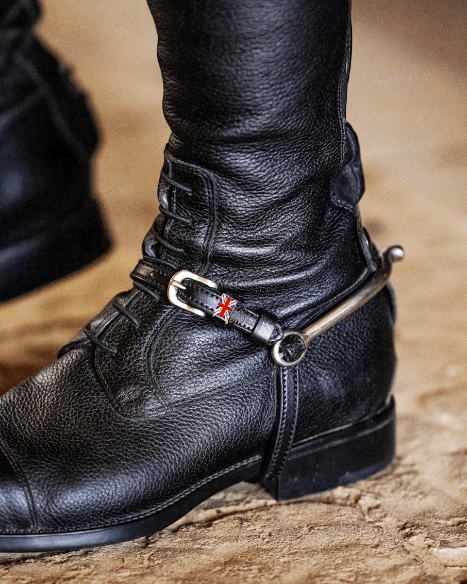 ManeJane Union Jack spur strap fastened with a spur on a rider's black riding boot