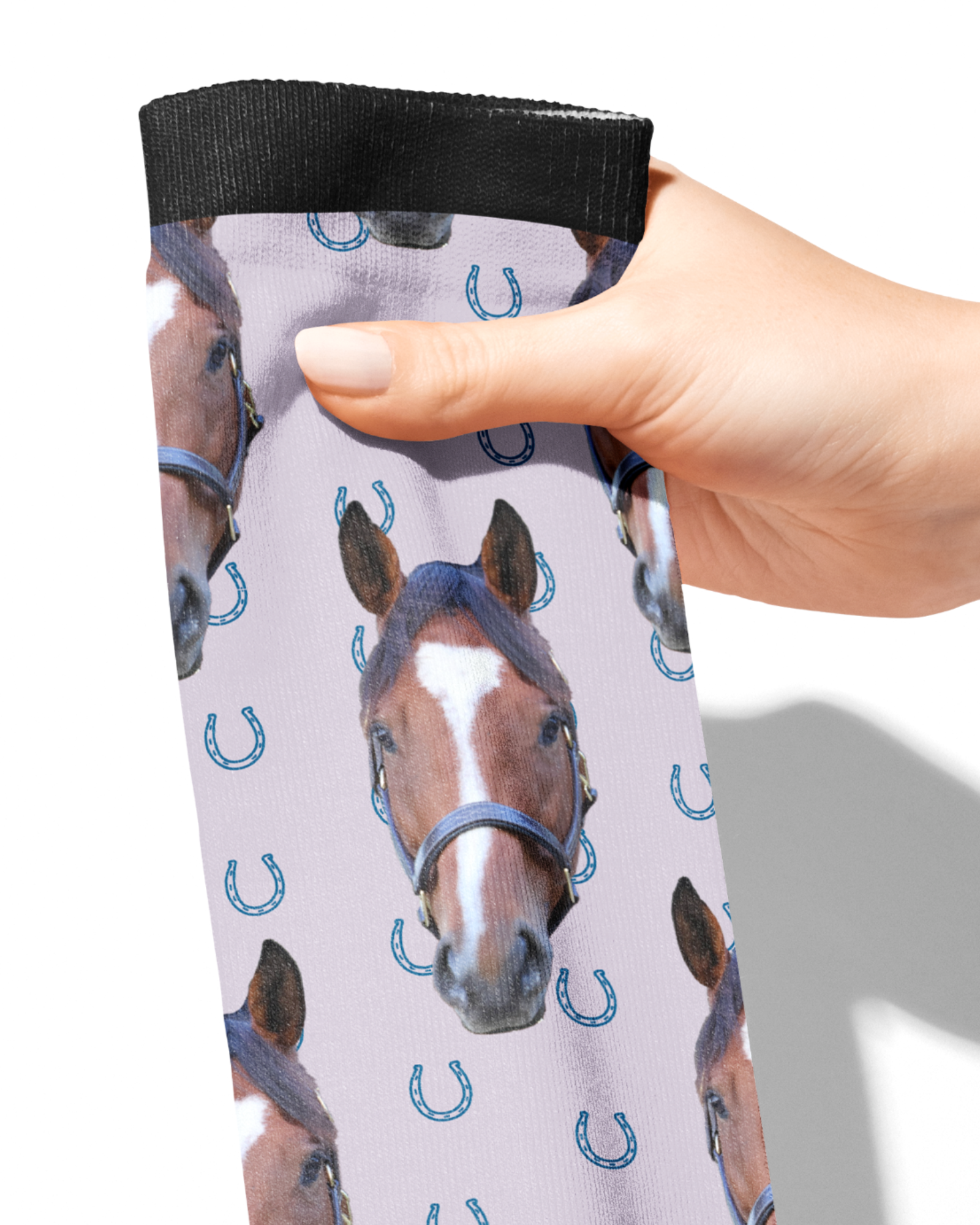 Custom Solo socks with blue horseshoes and horse photo pattern held in hand
