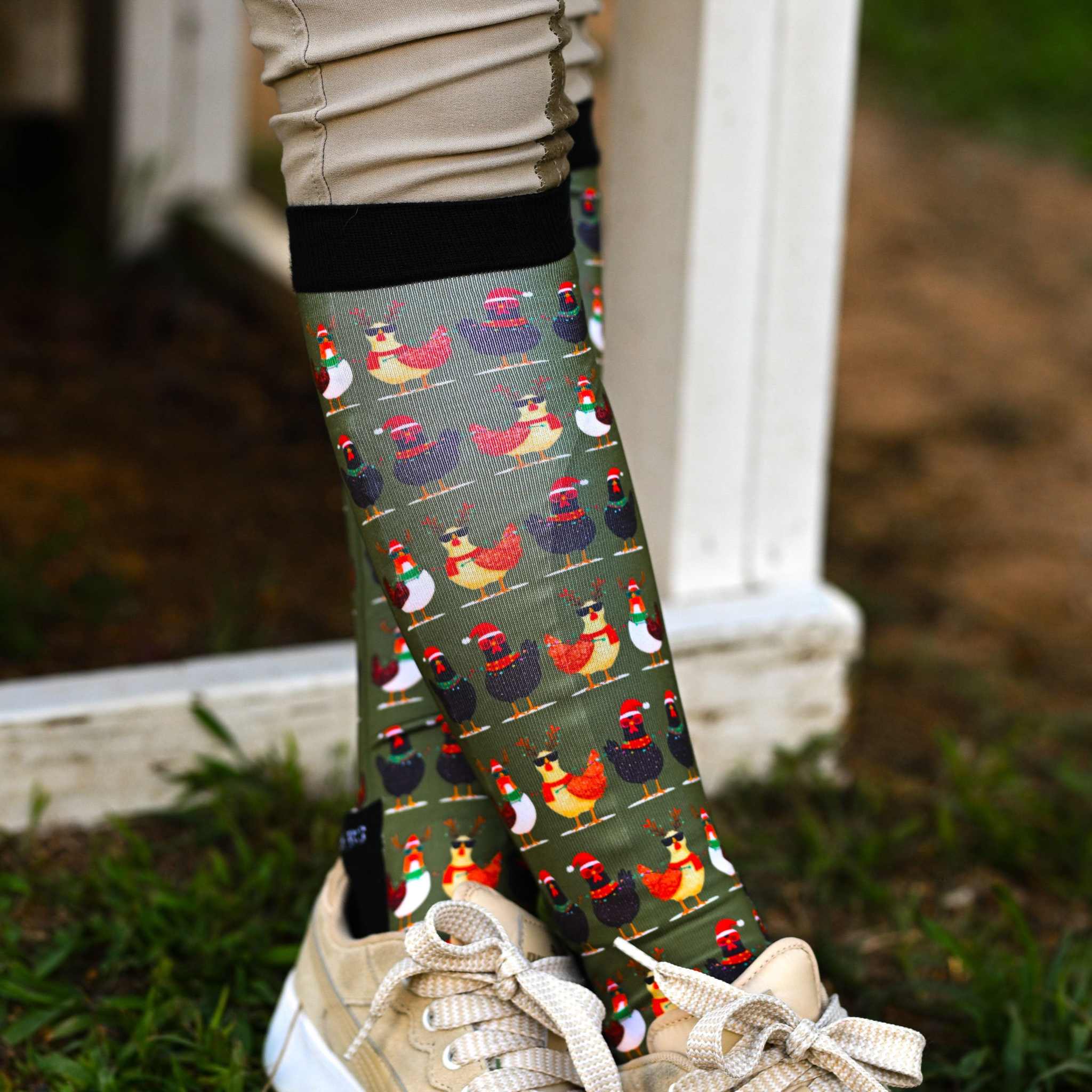 holiday-themed boot socks with colorful chicken pattern and black stretchy top worn with beige boots