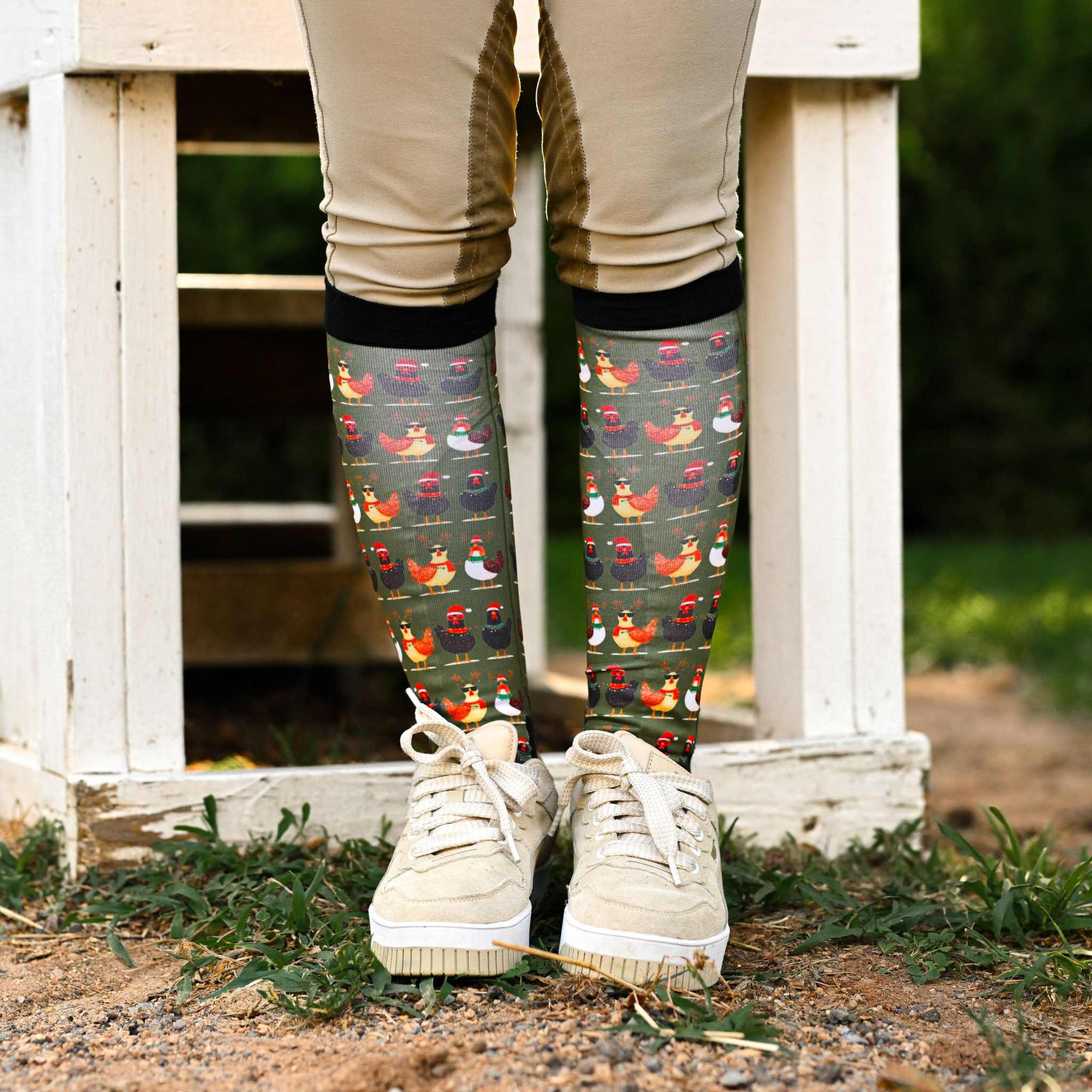 Holiday-themed boot socks with colorful chicken pattern, stretchy black top, and terry foot bottom for comfort and protection.
