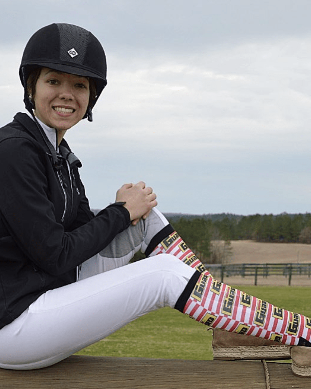 Woman wearing custom D&S riding boot socks with colorful striped design outdoors