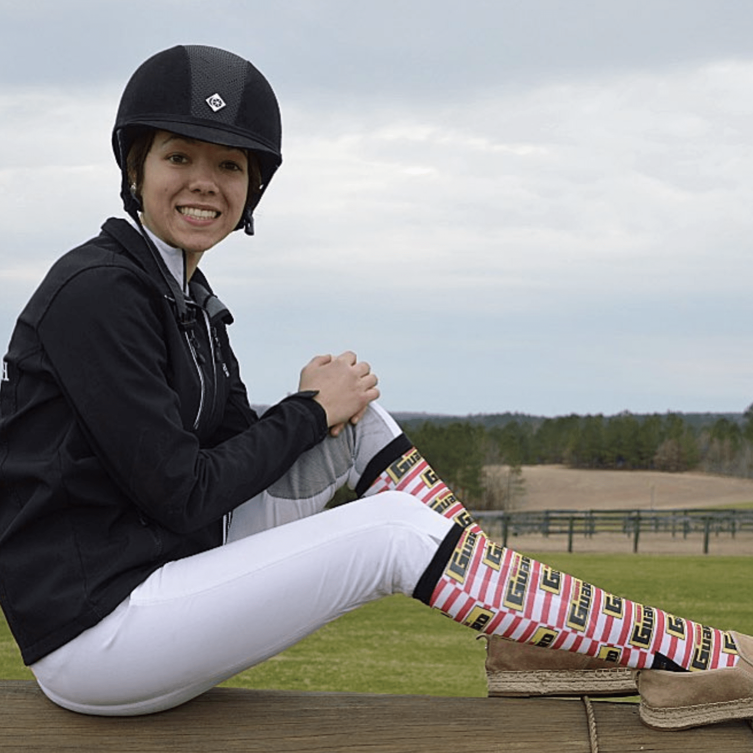 Woman wearing custom D&S riding boot socks with colorful striped design outdoors