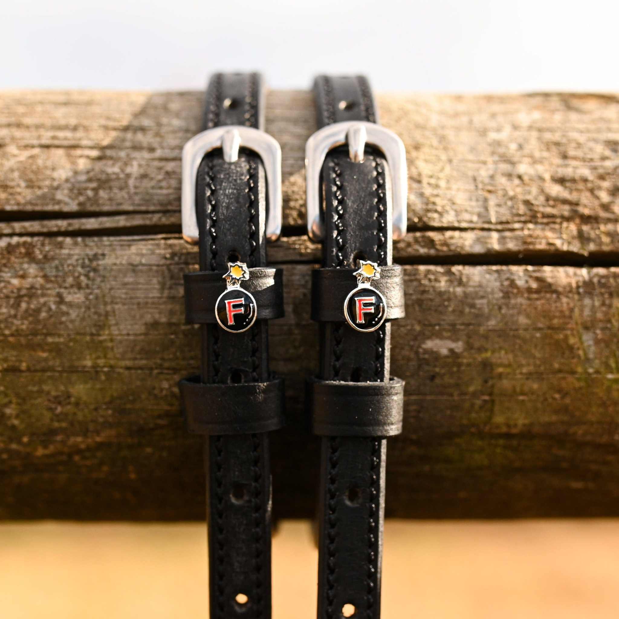 Black leather spur straps with silver buckles and F-Bomb charm from Ultimate F-Bomb Pack equestrian accessories.