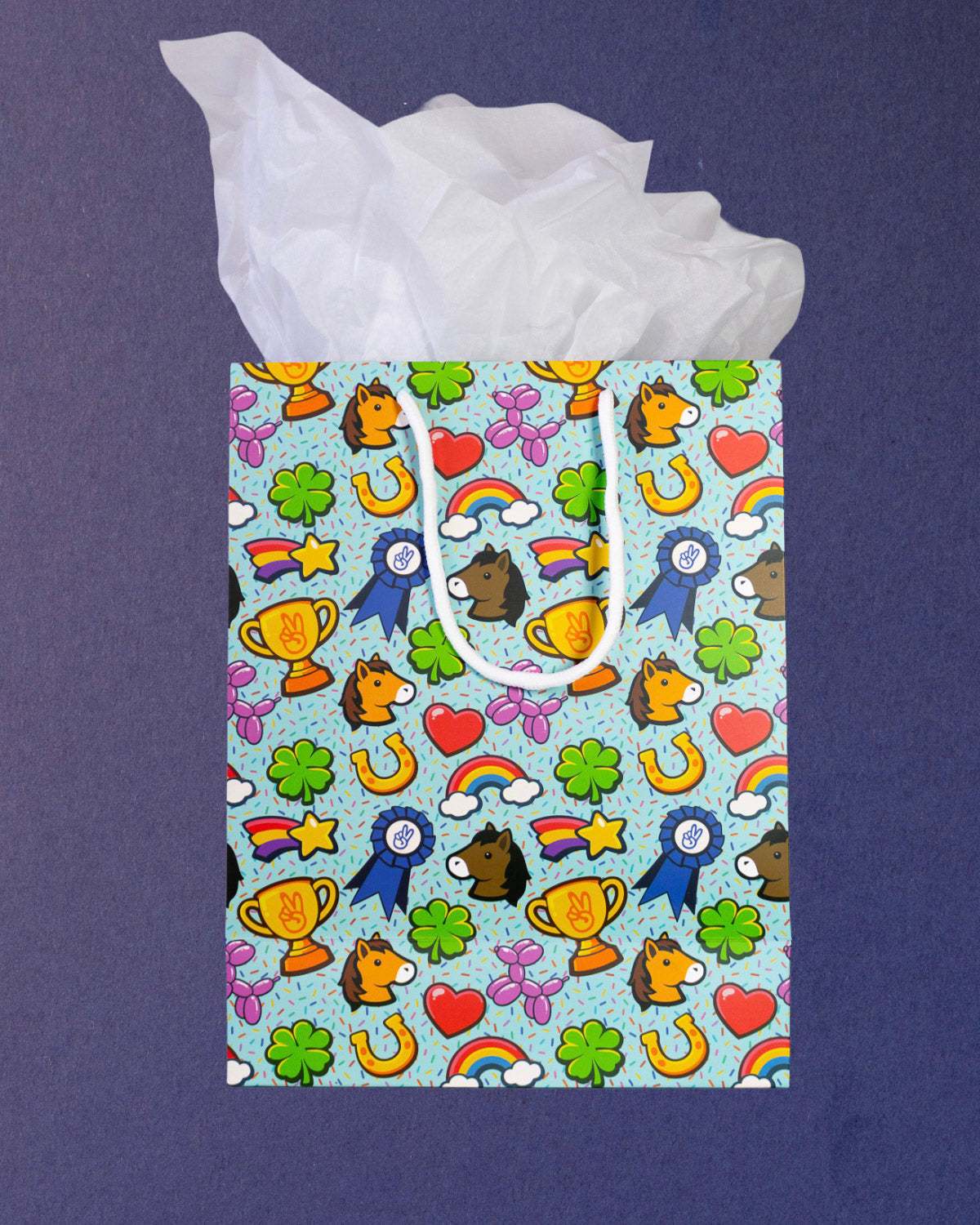 Full O' Luck medium gift bag square to camera, tissue paper spread wide above the lucky charm print.