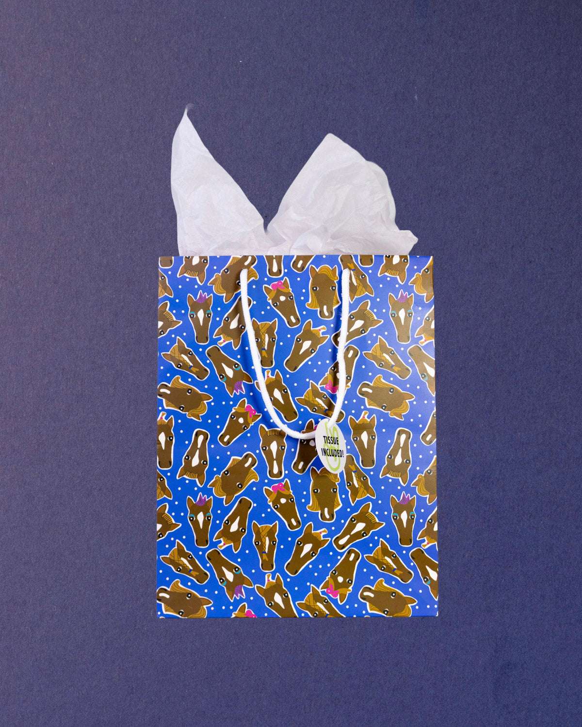 Hairy Styles medium gift bag standing front-on, tissue paper in two peaks above the blue pony print.