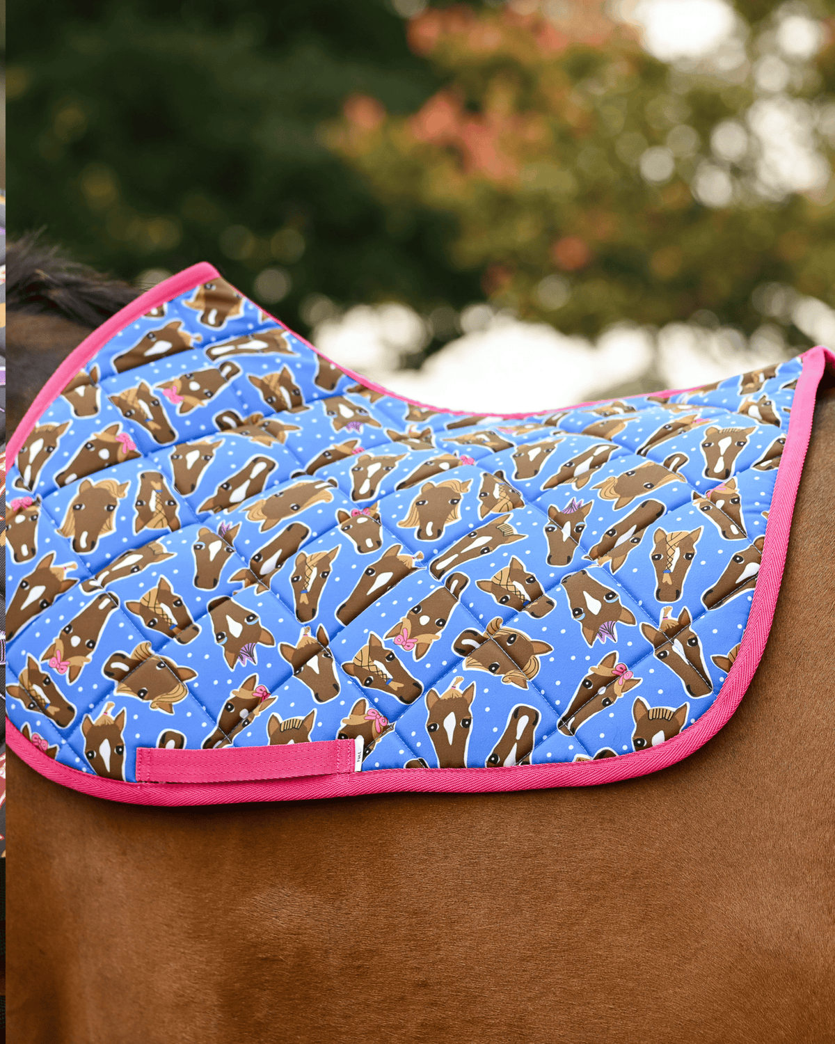 Bright blue Hairy Styles pad printed with brown horse heads in bows and braids, hot pink binding, no saddle