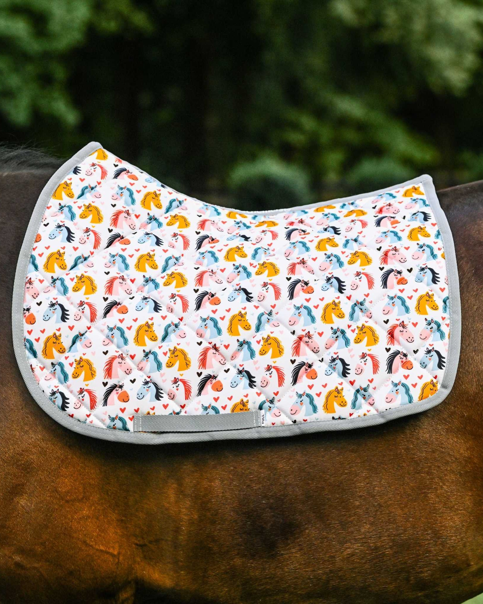 Just Horsing Around youth bundle saddle pad with colorful horse print on a horse's back