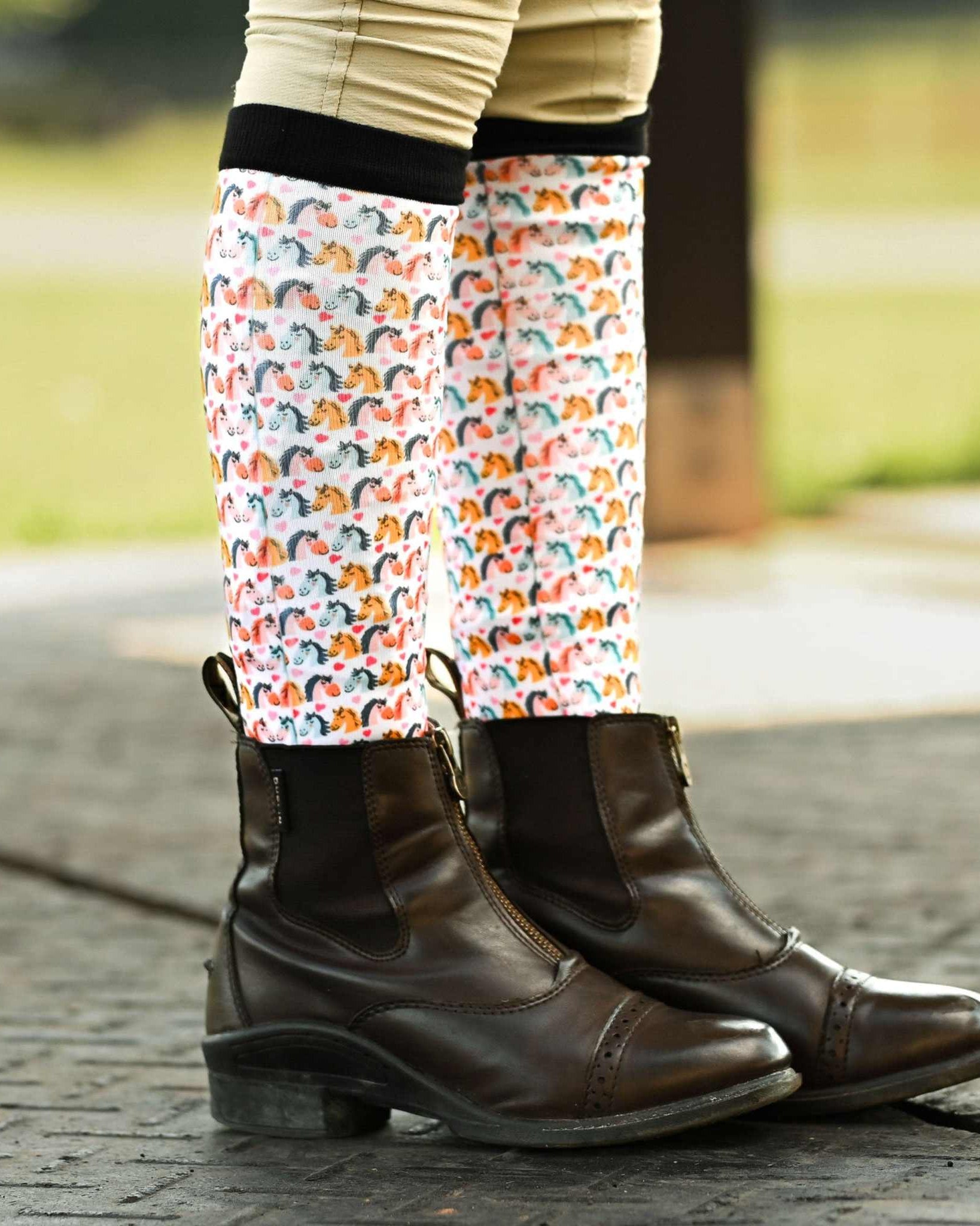 youth wearing Just Horsing Around horse patterned riding socks with brown equestrian boots