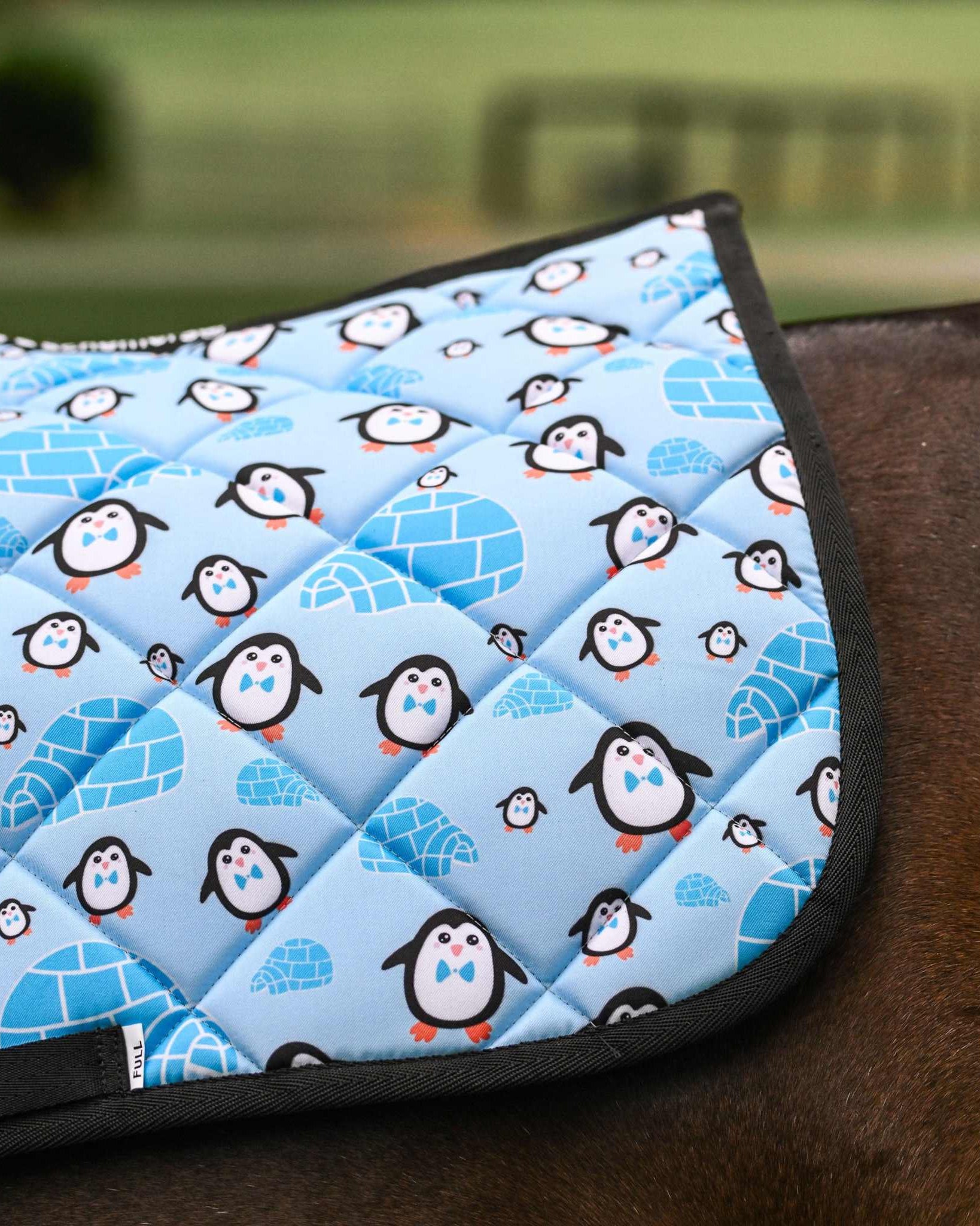 Igloo Crew Saddle Pad with penguin and igloo pattern on horse saddle cut for comfort and style