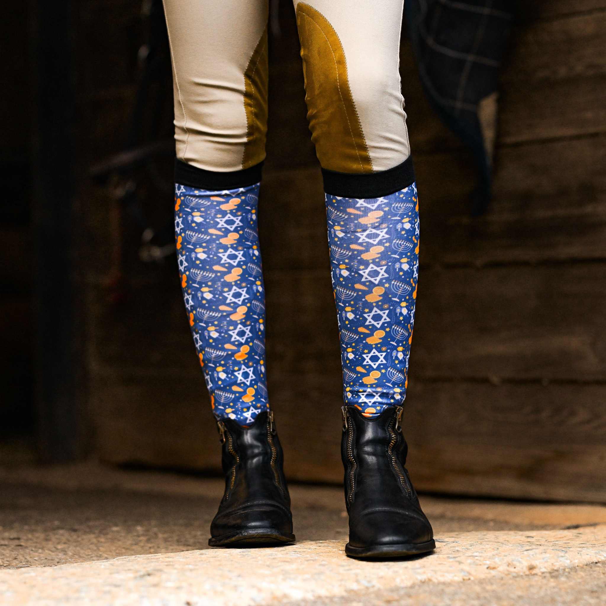 Blue Keep Calm & Dreidel On riding socks with Hanukkah symbols worn with black riding boots