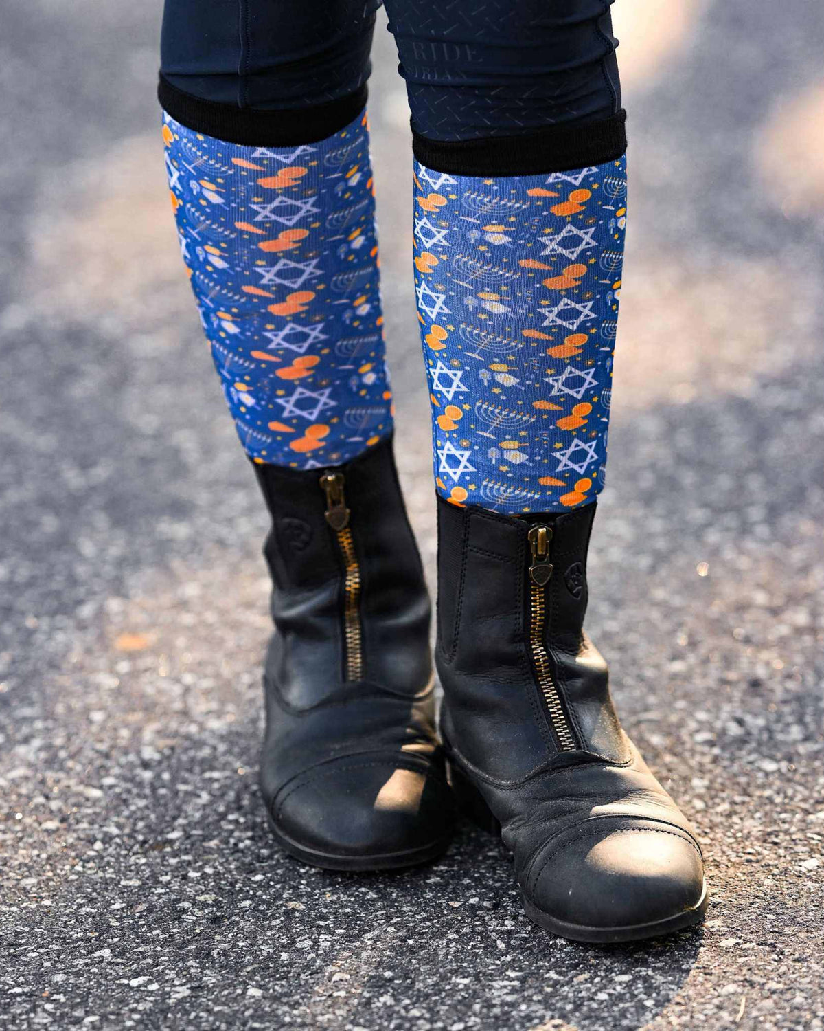 blue Keep Calm & Dreidel On riding socks worn with black riding boots on pavement