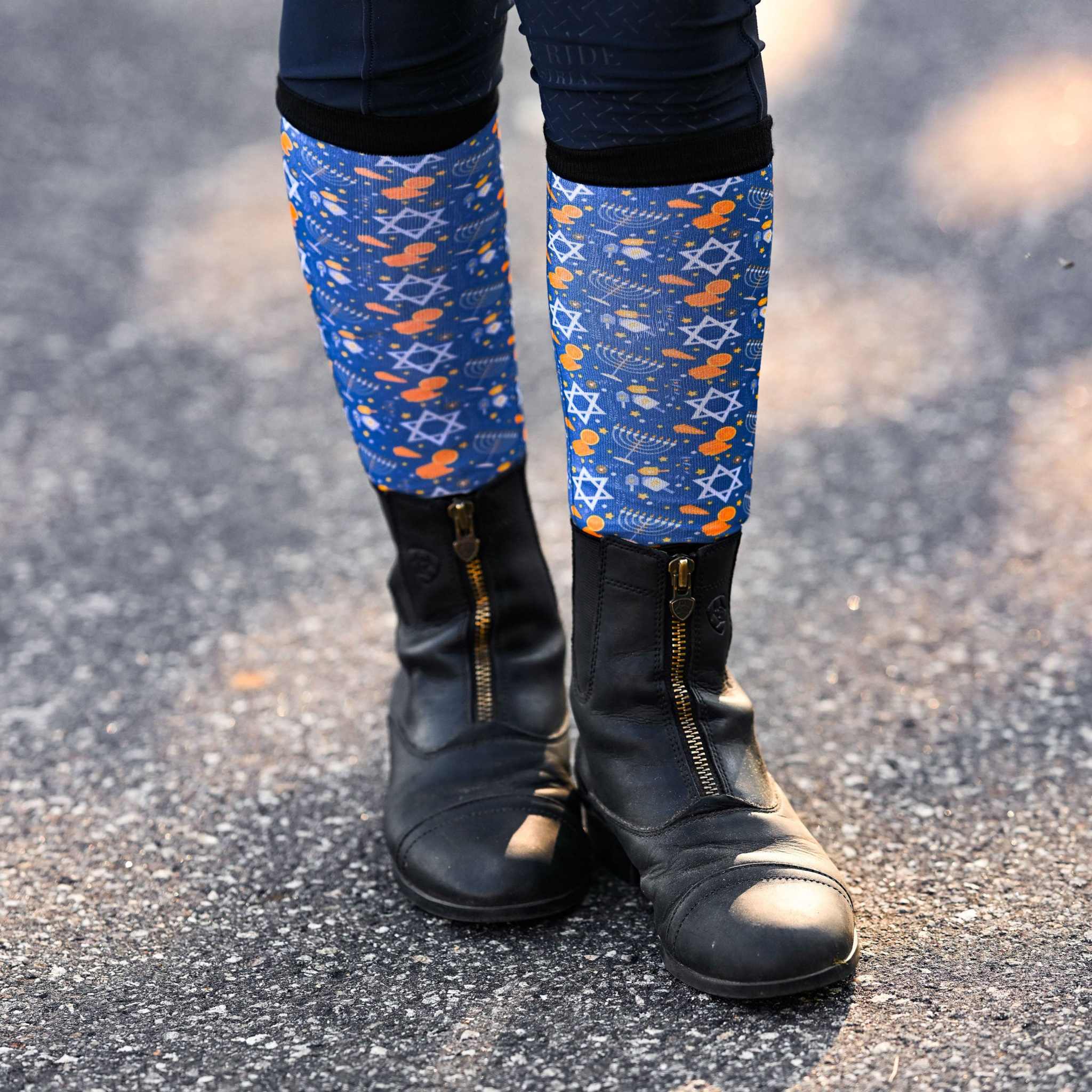 blue Keep Calm & Dreidel On riding socks worn with black riding boots on pavement