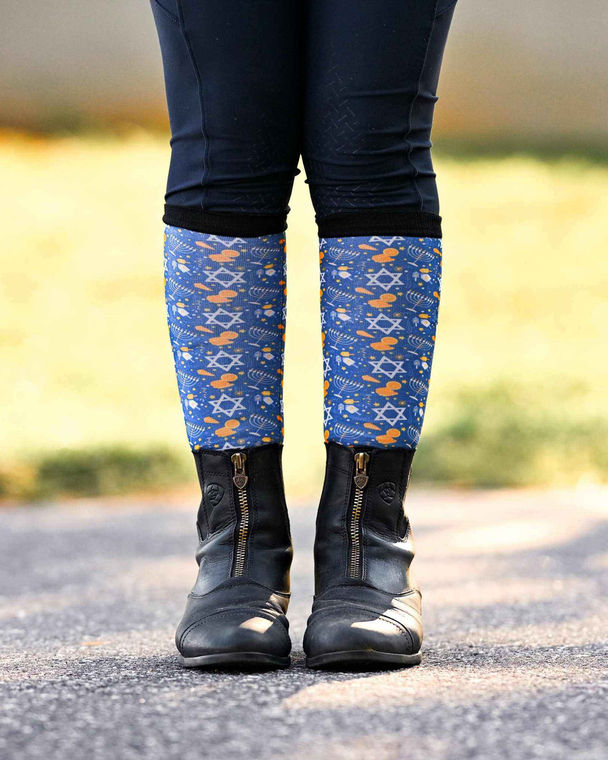 Youth riding socks with Keep Calm & Dreidel On design, blue holiday pattern, worn with black boots