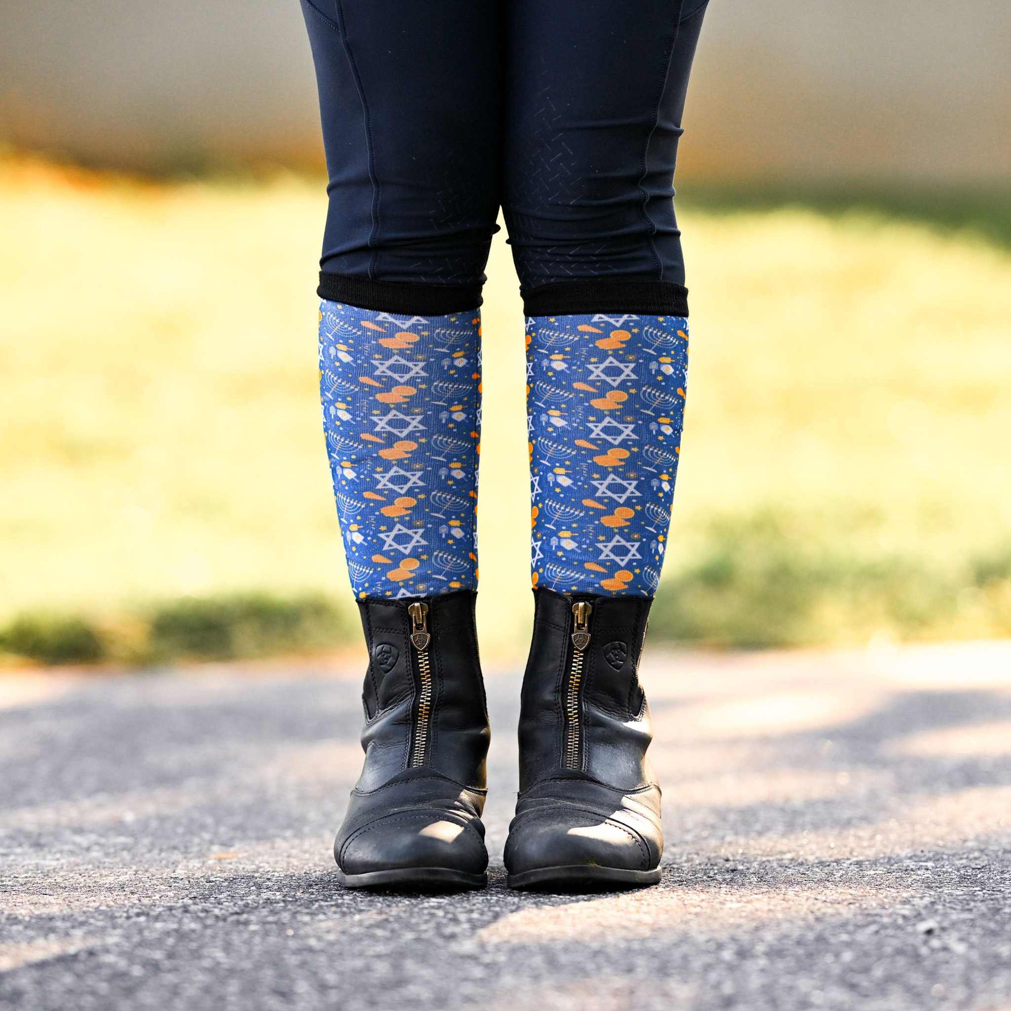 Youth riding socks with Keep Calm & Dreidel On design, blue holiday pattern, worn with black boots