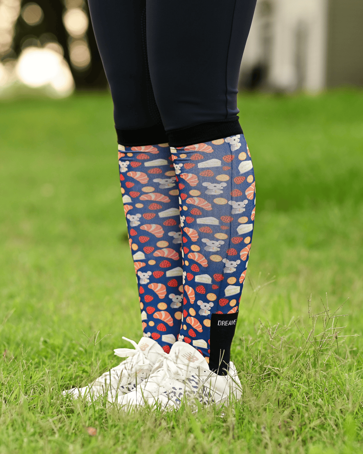 Merci equestrian boot socks worn at the barn, navy with croissants, macarons and strawberries
