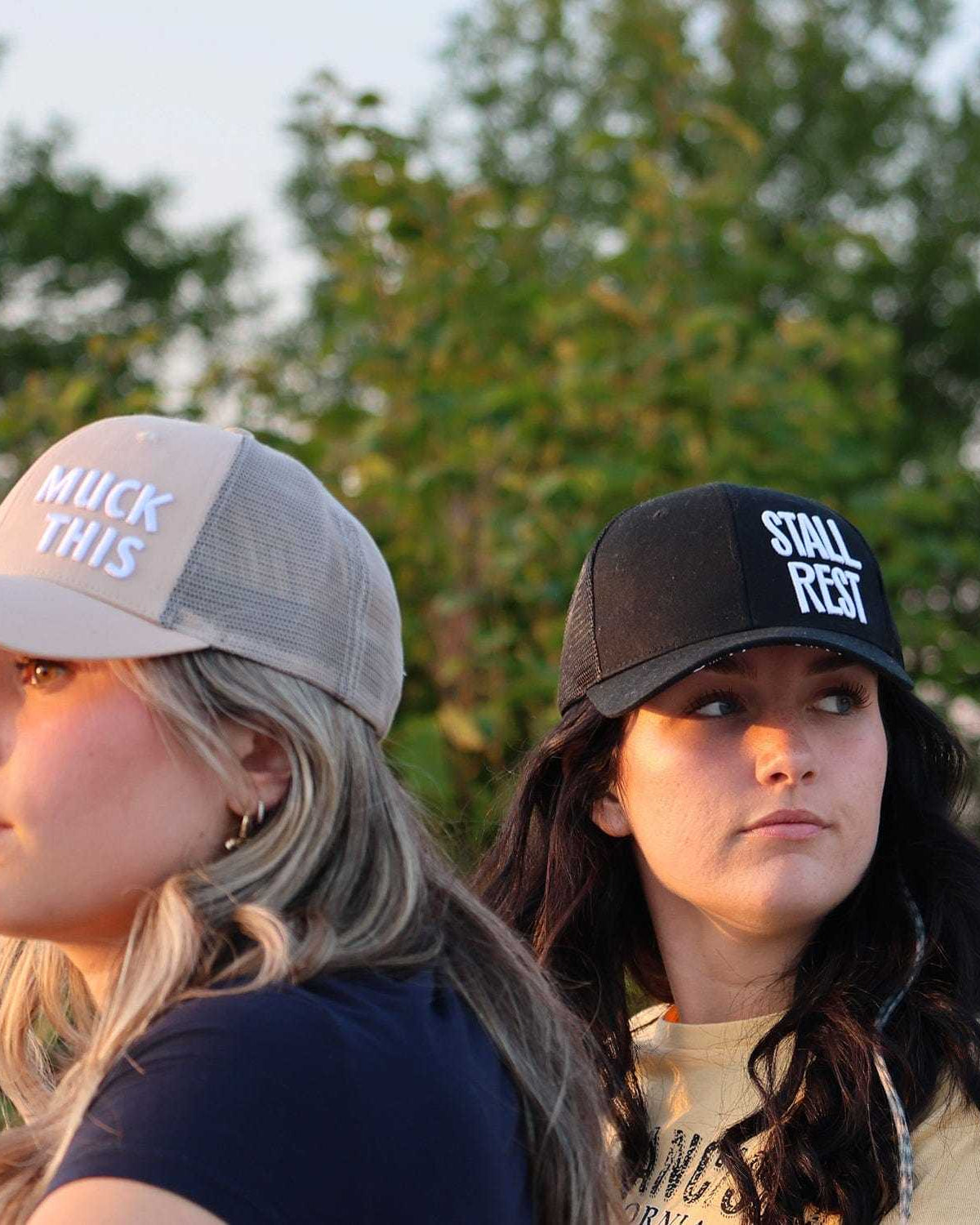 Two women wearing Muck This Equestrian Bundle trucker hats in outdoor setting