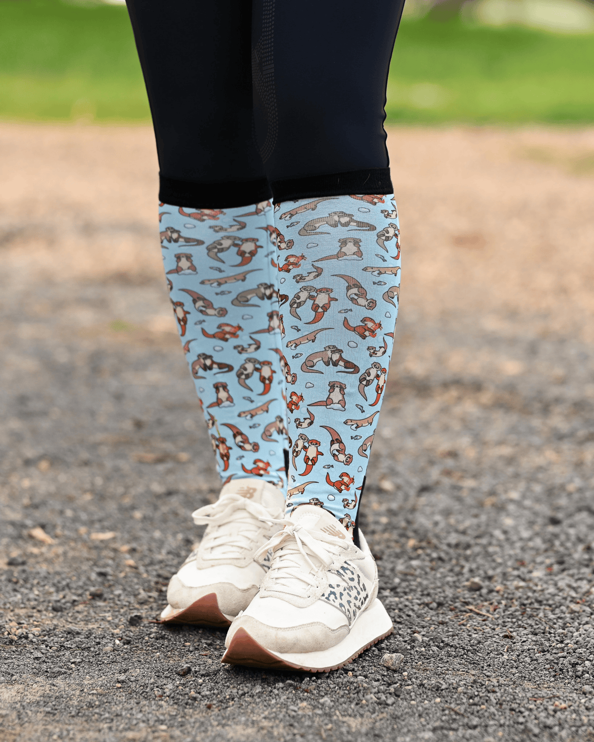 Otter-ly Adorable equestrian boot socks worn at the barn, pale blue with otters floating and holding hands