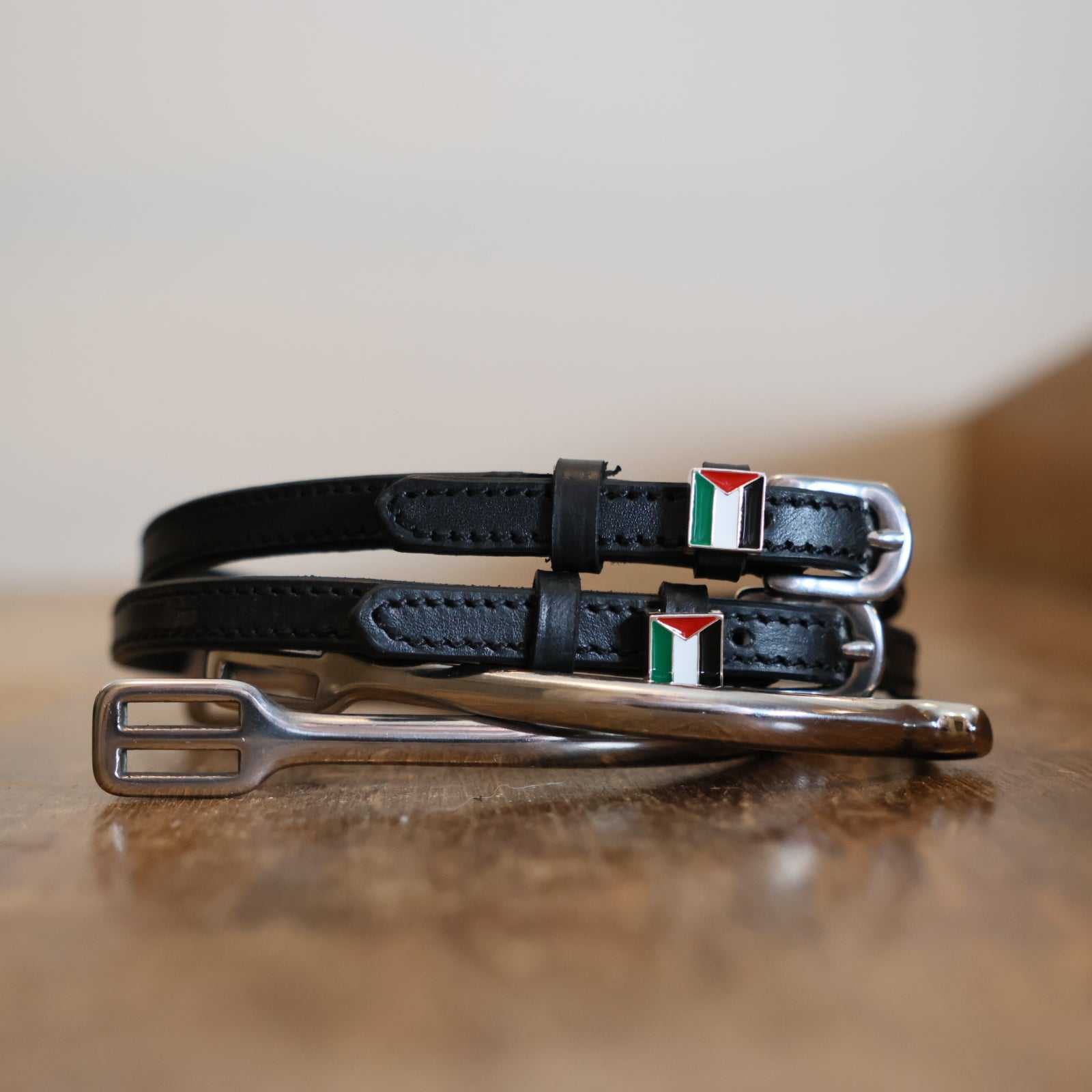 Black leather spur straps with Palestine flag charm and stainless steel buckle