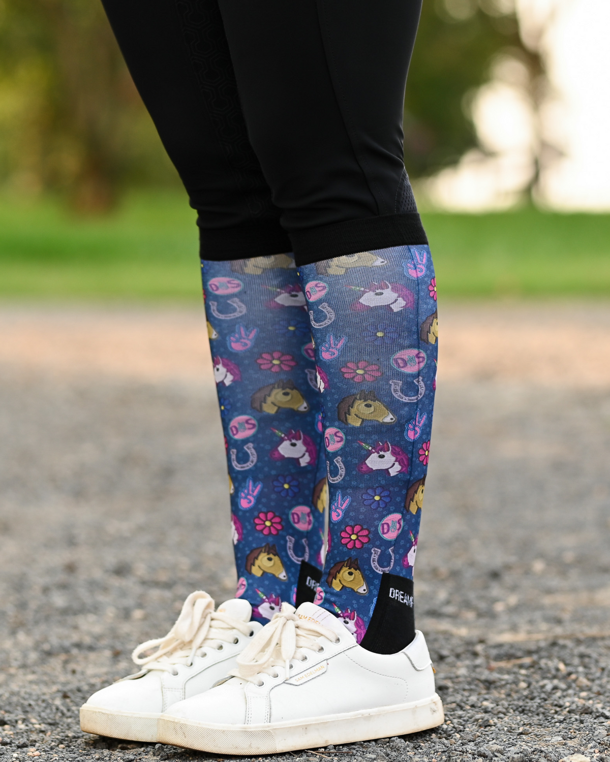 Patch Perfect riding boot socks styled over breeches, navy with unicorn, horseshoe and daisy patch badges