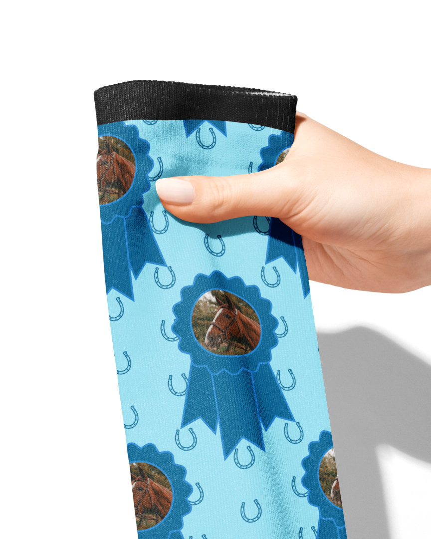 Hand holding custom blue ribbon socks with horse photo and blue horseshoe pattern