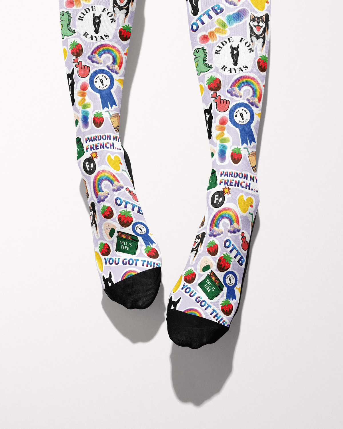 Friendship socks shown from the toes, black toe caps with blue ribbons, strawberries and Ride for Rayas logos