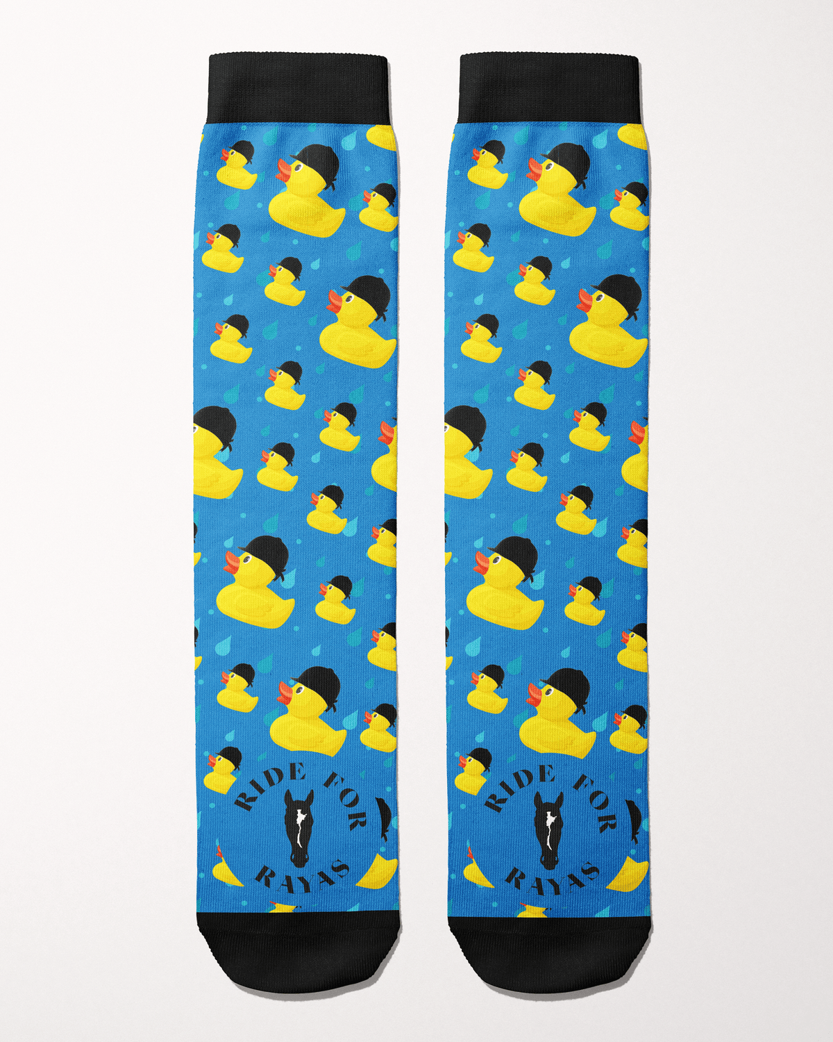 Ride for Rayas Rubber Ducky equestrian boot socks in bright blue with helmet-wearing ducks, flat lay, by Dreamers & Schemers
