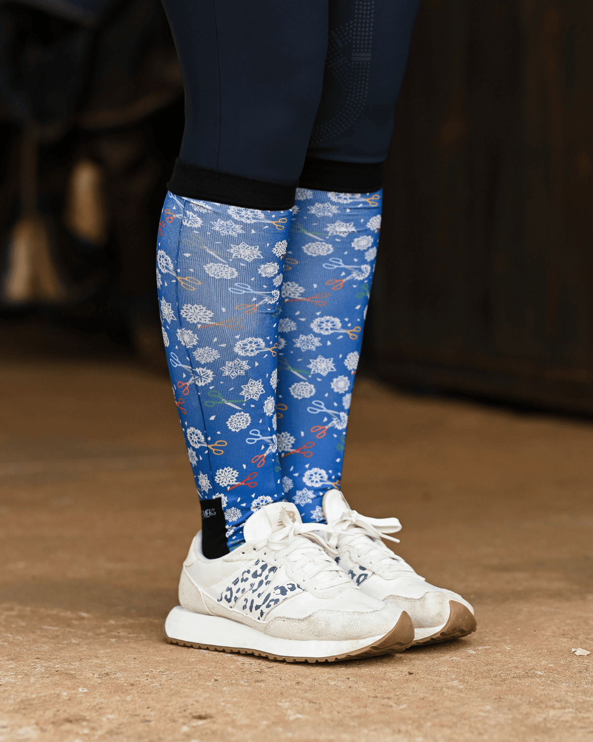 Shear Magic equestrian boot socks worn at the barn, cobalt blue with white clip rosettes and coloured scissors