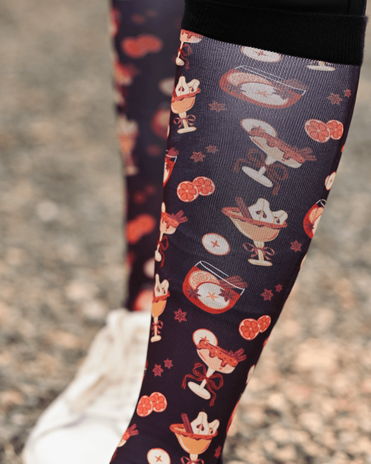 Close crop of the Stir Crazy boot sock print, cocktail glasses and citrus slices on dark plum
