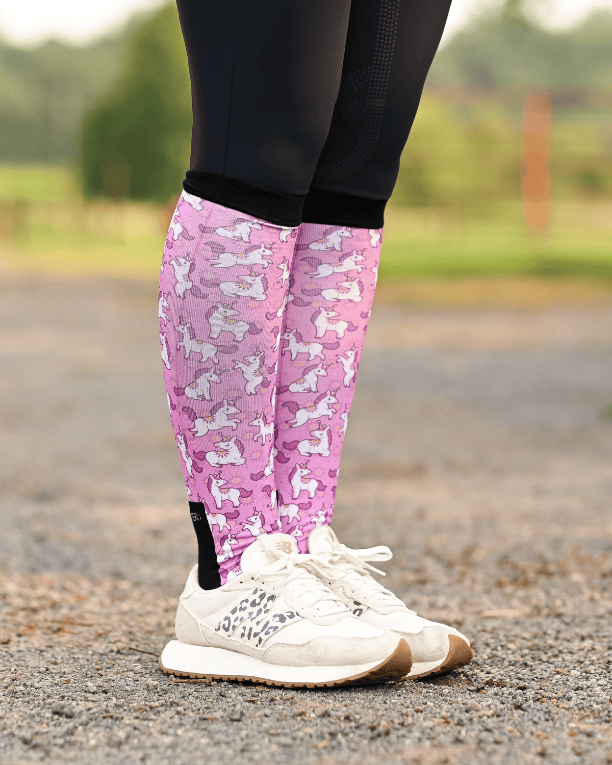 Sunshine and Unicorns equestrian boot socks worn at the barn, bright pink with white unicorns and yellow suns