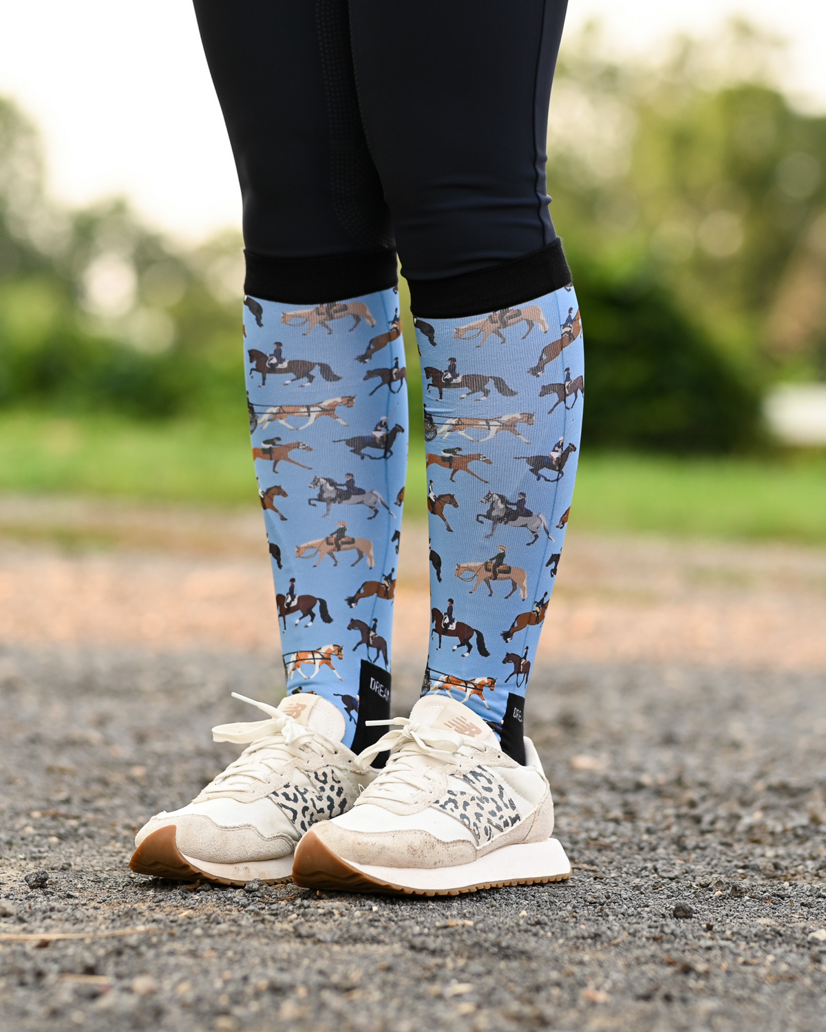 The Pony Island Horse Sports riding boot socks styled over breeches, light blue with riders mounted across every discipline