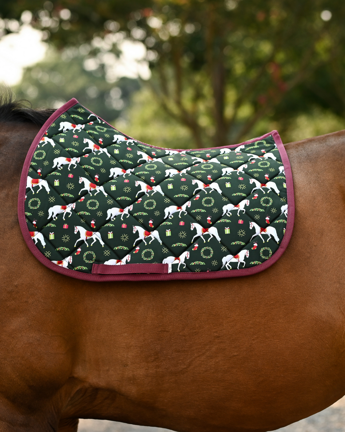 Lippizan Horses saddle pad in dark green with white dressage horses and wreaths, shown unsaddled