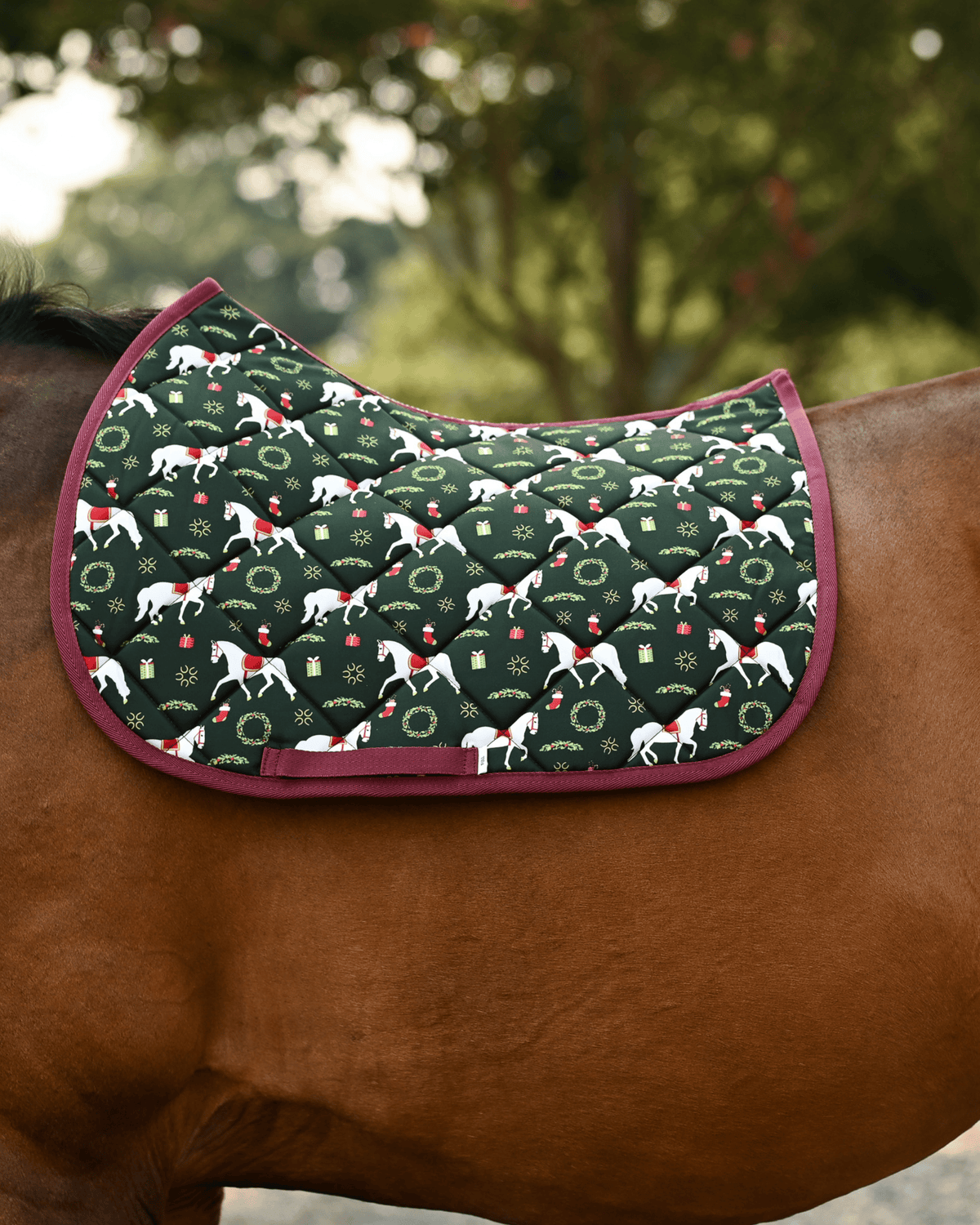 Lippizan Horses saddle pad in dark green with white dressage horses and wreaths, shown unsaddled