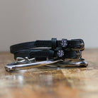 Black leather Disco Ball Spur Straps with stainless steel buckle and custom charm on peg wall display card