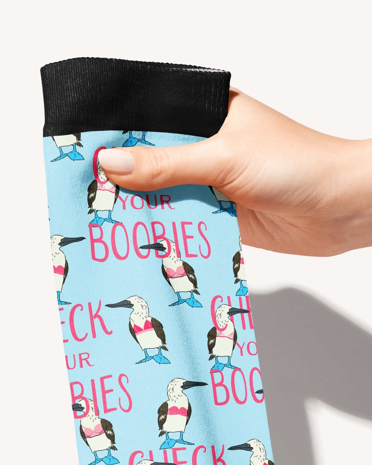 Check Your Boobies Limited Edition boot socks, blue-footed boobies and pink lettering on sky blue, held in hand, close-up of the print, by Dreamers & Schemers