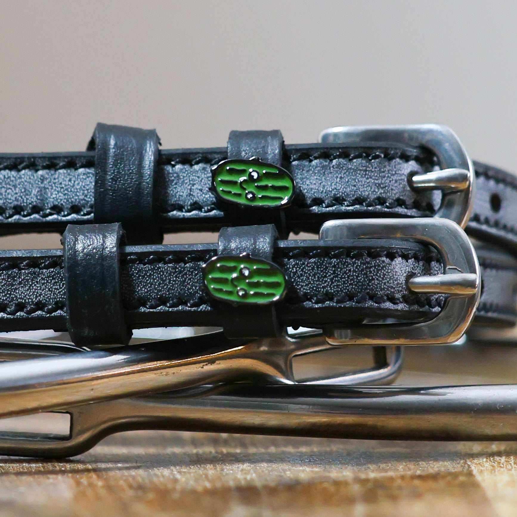 Pickles Spur Straps black leather with stainless steel buckle and green pickle charm close-up