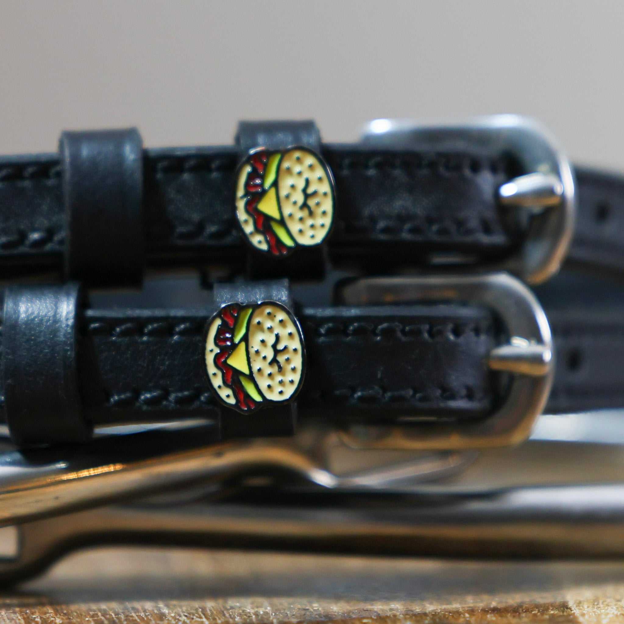 Black leather bagel sandwich spur straps with stainless steel buckles and custom charms