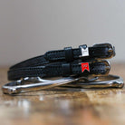 Black leather Jump Flags Spur Straps with stainless steel buckle and custom charm on peg wall display