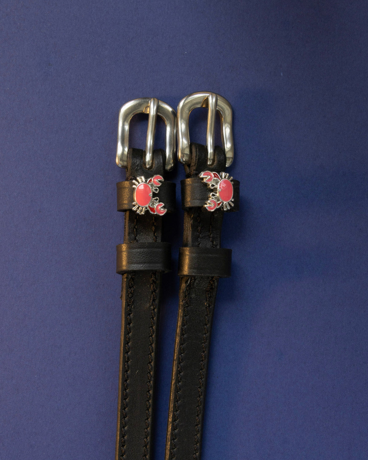 Crabbin' ManeJane spur straps with the signature Crabbin' charm, shown on a navy background