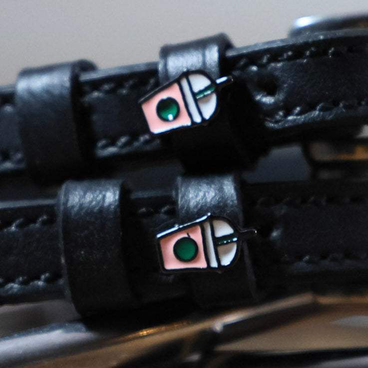 Black leather Frappe Spur Straps with stainless steel buckle and custom charm for durable, stylish riding gear