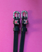 Crabbin' ManeJane spur straps with the signature Crabbin' charm, shown on a pink background