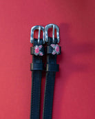 Crabbin' ManeJane spur straps with the signature Crabbin' charm, shown on a red background