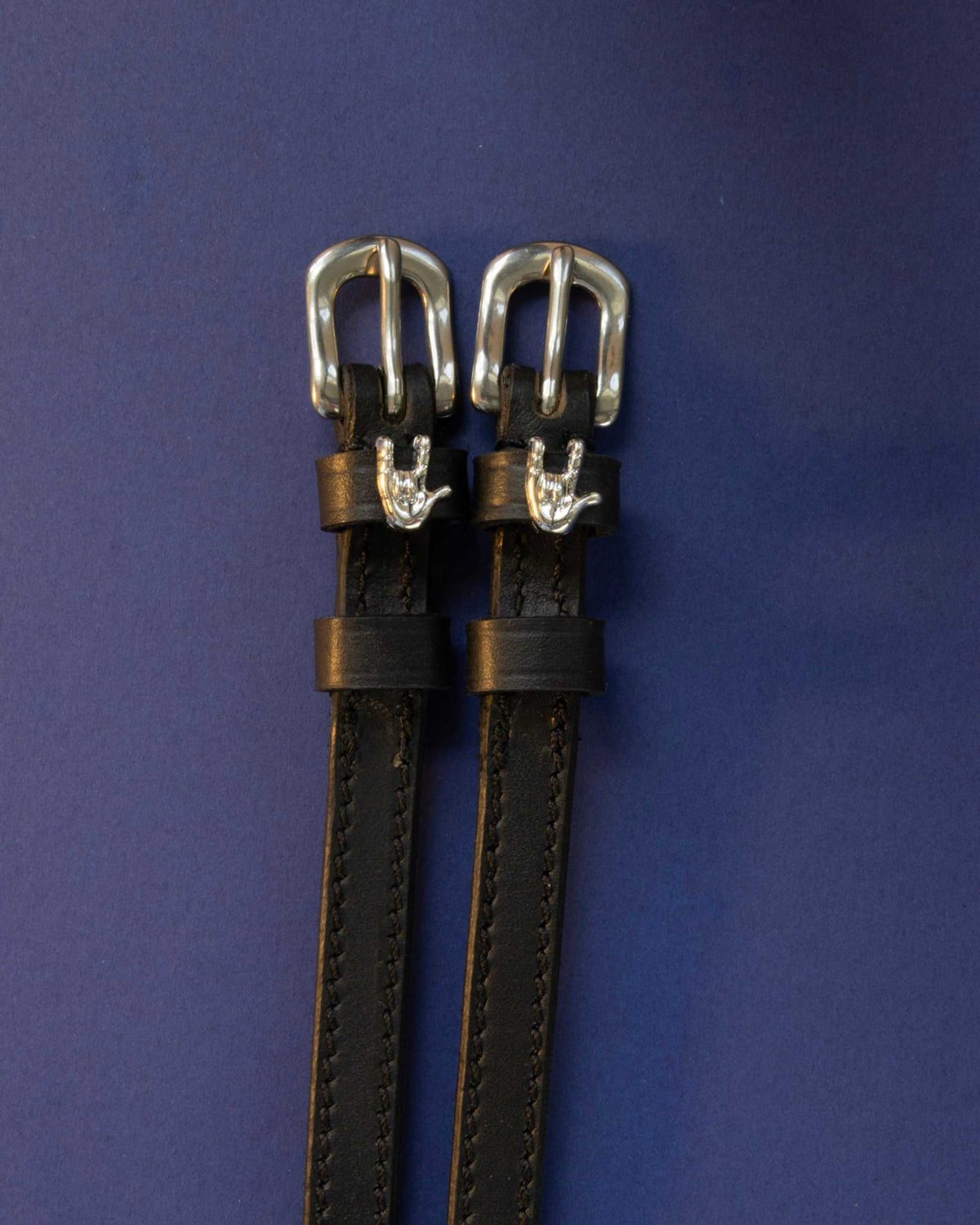 Rock On ManeJane spur straps with the signature Rock On charm, shown on a navy background