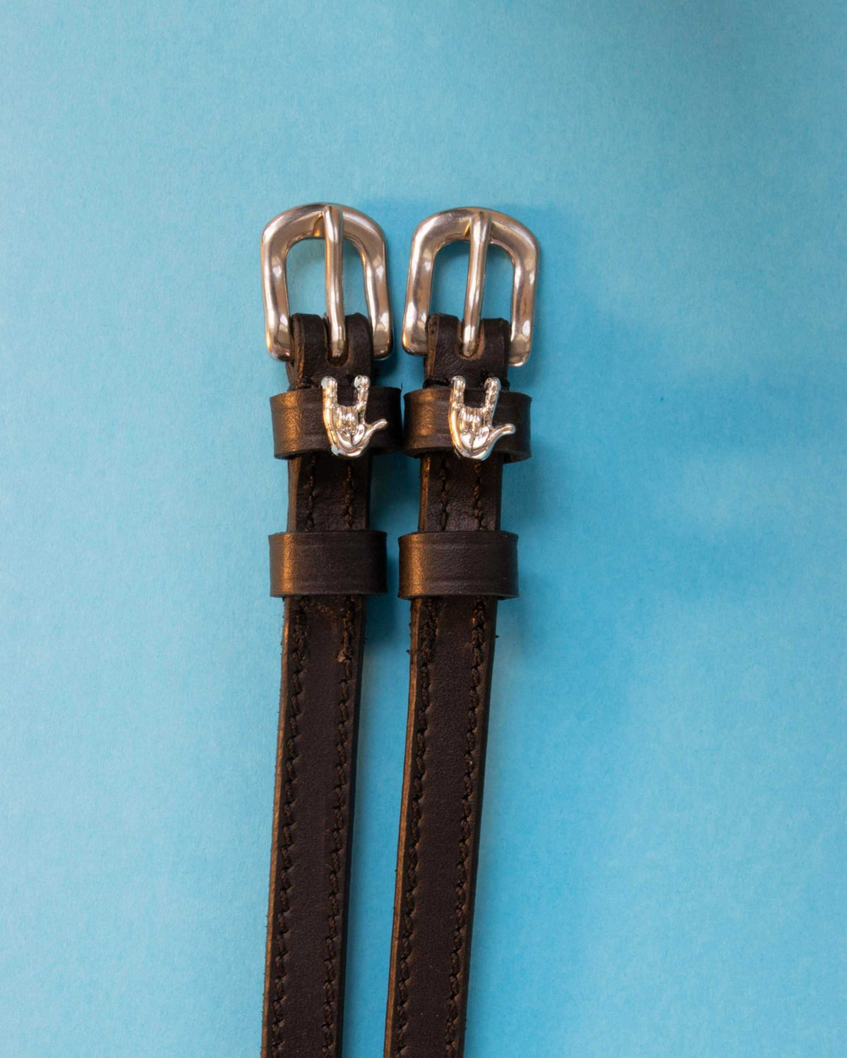 Rock On ManeJane spur straps with the signature Rock On charm, shown on a light blue background
