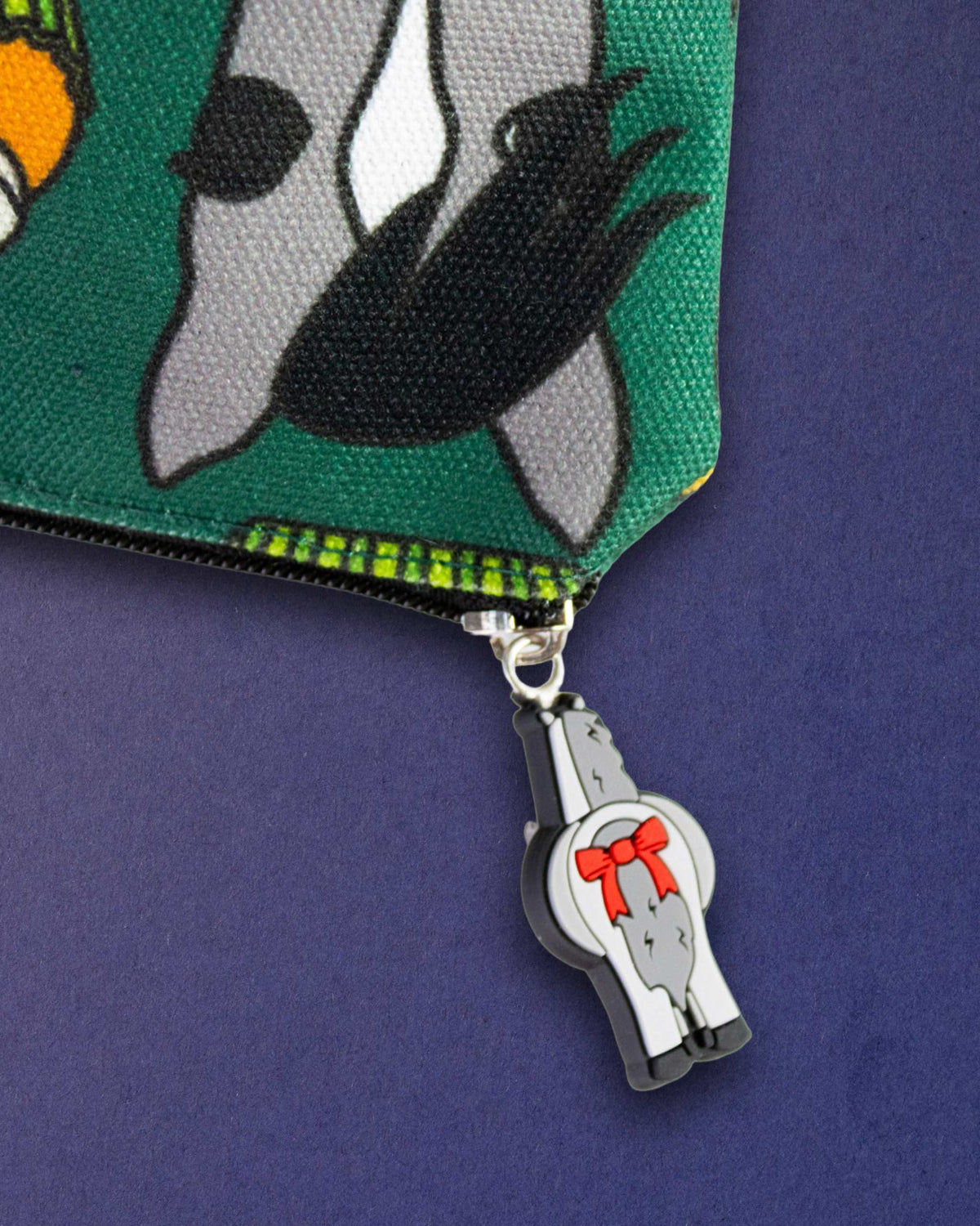 Close-up of the bad pony zip pull charm on the black zip of the Carrot Cake pouch